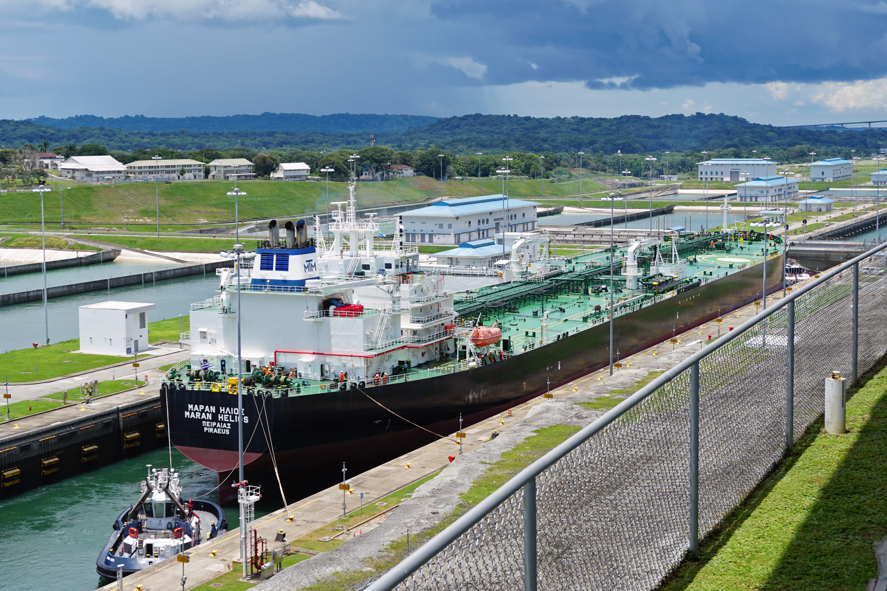 Historical photograph of a vessel and tugboats inside the Panama Canal's Agua Clara locks